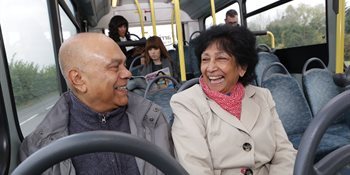 Man and woman sitting on a bus laughing